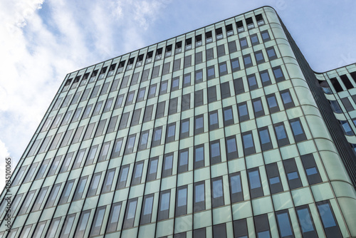 Modern architectural marvel soaring skyward  featuring sleek lines  reflective windows  and contemporary design against a blue sky.