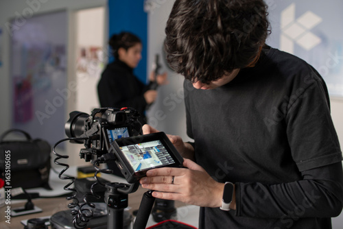 Joven camarógrafo preparando cámaras y monitor en gimbal para registro audiovisual video