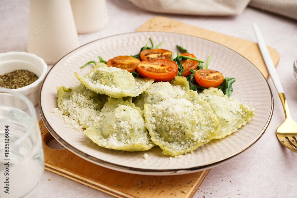 Plate of tasty ravioli with tomatoes and cheese on white background Plate of tasty ravioli with tomatoes and cheese on white background