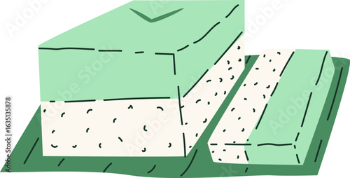 A pastel green layered dessert, possibly a type of cake or sweet, rests on a leaf-like surface, a portion sliced off.