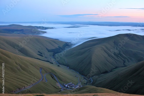 Misty valley winding road, mountain peaks