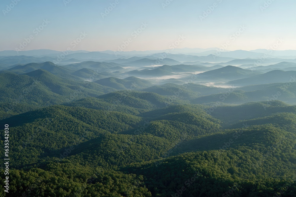Fototapeta premium Misty mountain range at dawn. Lush green hills fade into hazy blue distance