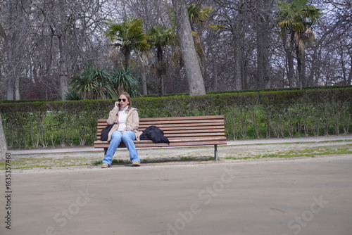 Young Woman Relaxing on a Bench in El Retiro Park Madrid Spain on a Sunny Day