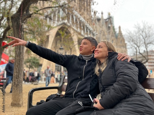 Young couple sitting on a bench in the Sagrada Familia in Barcelona talking