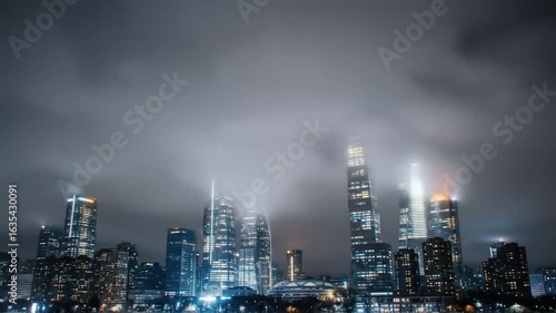 Wallpaper Mural A foggy night skyline view of a bustling city with illuminated skyscrapers and clouds Torontodigital.ca