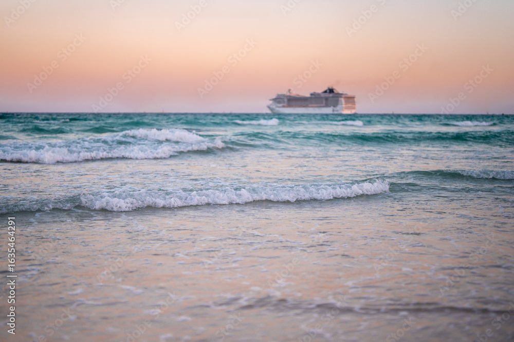 Obraz premium Cruise ship on the ocean. Luxury liner at ocean waves water. Miami Beach with cruise ship. Turquoise water and cruise liner. Tourist cruise ship near the coast. Ocean waves and vessel boat.