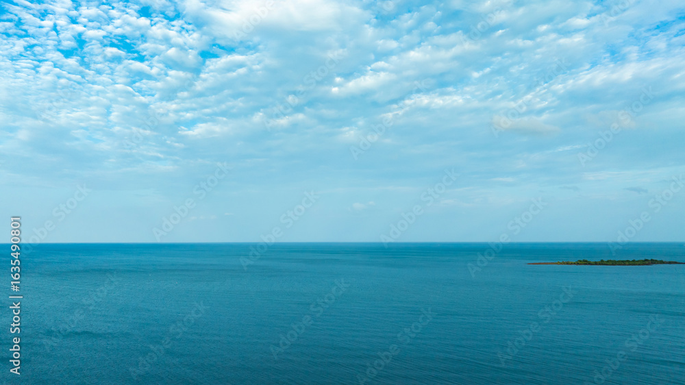 Obraz premium Nature of the ocean and blue sky Summer with sunshine, sandy beaches, clear blue waters sparkling against the blue sky. on an island with good ecology and environment Background for summer vacation