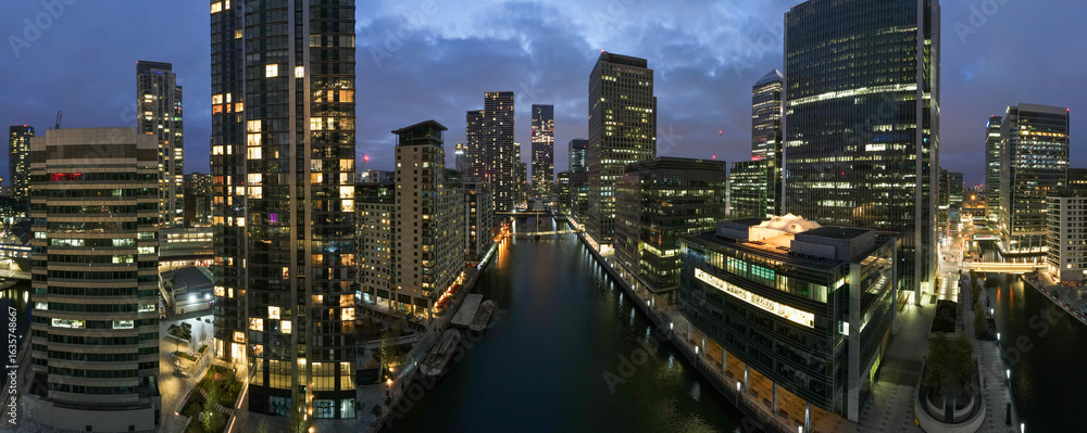 Fototapeta premium London night cityscape panorama view. Canary wharf financial district business hub. Modern skyscraper architecture reflection water with building light