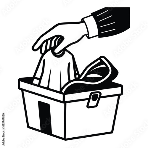Hand placing clothing into a donation box