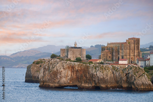 Bilde på lerret Santa maria de la asuncion church and lighthouse overlooking the cantabrian sea
