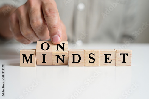 Hand places wooden block to spell out the word mindset