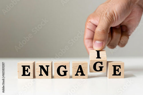 Hand placing the letter i on wooden blocks to spell the word engage