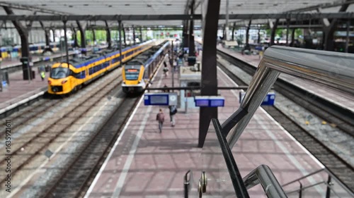 Rotterdam Netherlands July 12 2025. Selective focus. Yellow and blue NS trains on the platform of Rotterdam Central Station with passengers and modern canopy.