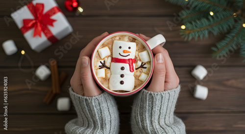 christmas, winter holidays and leisure concept - close up of hands holding cup of coffee with marshmallow snowman