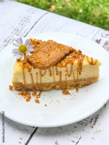 Biscoff Cheesecake with biscoff biscuit and edible flower on top