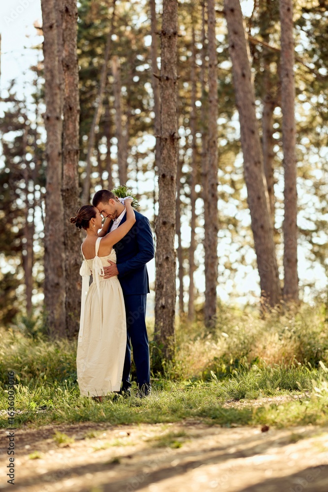 Fototapeta premium Romantic Wedding Couple Embracing in a Magical Forest Setting