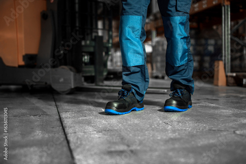 Close-Up of Worker in Protective Safety Shoes Standing on Warehouse Floor