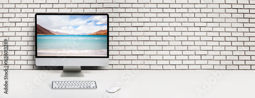 Computer with beach and ocean on screen monitor on white table Isolated in clipping path. free space on brick wall for text
