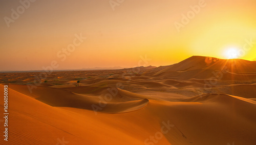 Desert Sunset with Sand Dunes and Sun Over Mountain