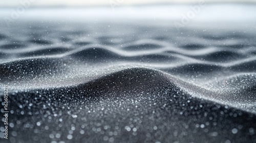 Wavy, textured surface covered in subtle silver sparkles in shallow depth of field