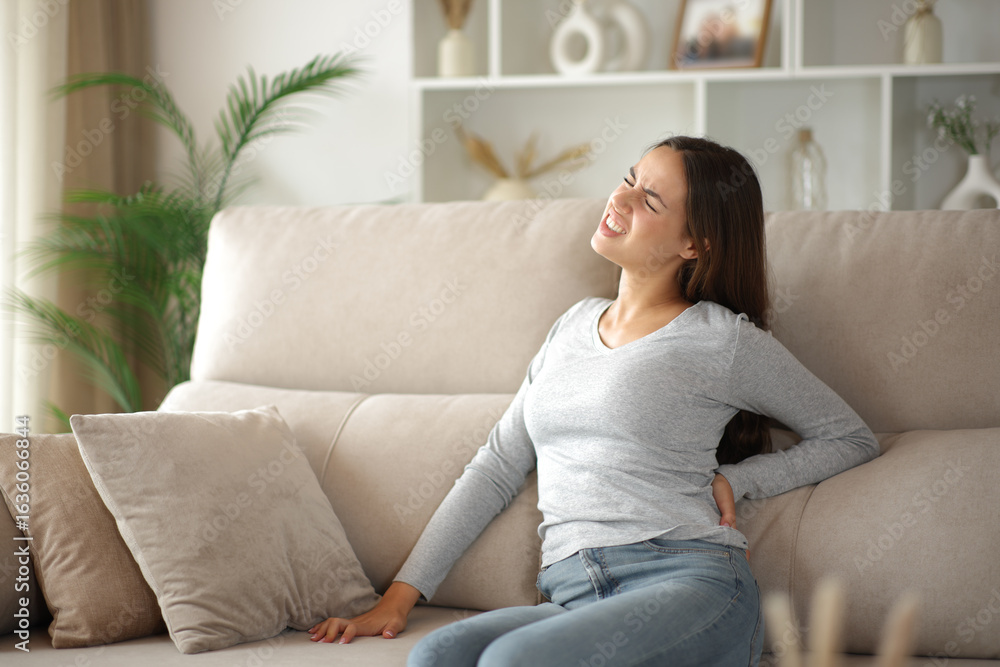 Woman complaining suffering back ache on uncomfortable sofa Woman complaining suffering back ache on uncomfortable sofa