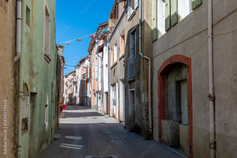 Fototapeta premium Vieilles maisons traditionnelles avec des façades et des volets colorés, dans une rue étroite de Veynes, France, ville du département français des Hautes-Alpes, en région Provence-Alpes-Côte d'Azur