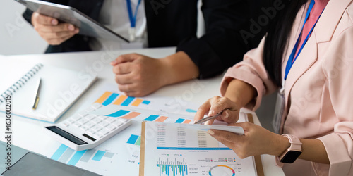 Data Analysis. Professionals reviewing financial documents and charts in a collaborative workspace.