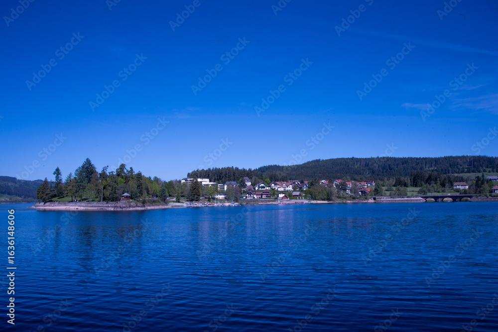 Schluchsee shimmers under the clear summer sky — a tranquil jewel of the Black Forest, perfect for sunlit reflections and peaceful escapes Schluchsee shimmers under the clear summer sky — a tranquil jewel of the Black Forest, perfect for sunlit reflections and peaceful escapes