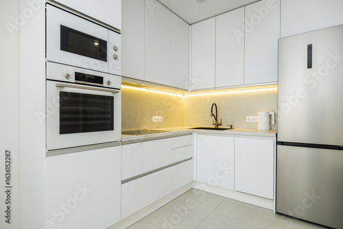 Modern kitchen design featuring sleek white cabinets, appliances, and stylish fixtures in a contemporary urban setting