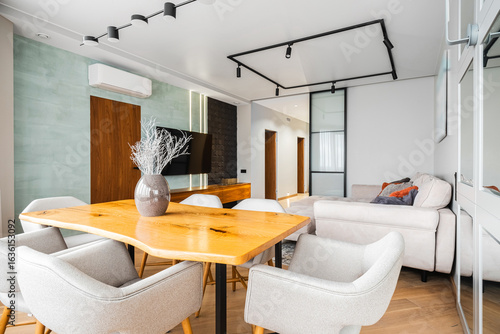 Modern living space features a stylish dining area and comfortable lounge with natural light and contemporary decor