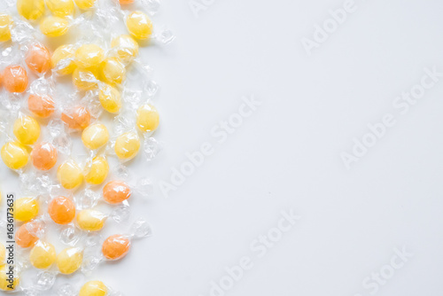Assorted citrus flavored hard candy wrapped on white background