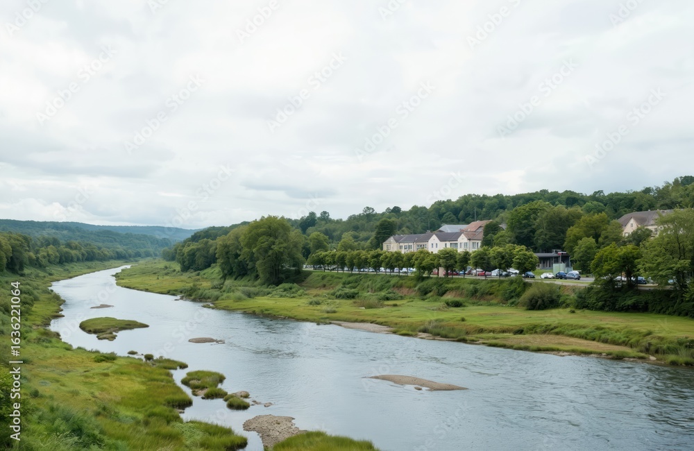 Serene river meanders through green valley under soft clouds. Gentle water reflects trees, sky along grassy banks. Distant village with houses, cars adds to peaceful afternoon scenery. Harmony with Serene river meanders through green valley under soft clouds. Gentle water reflects trees, sky along grassy banks. Distant village with houses, cars adds to peaceful afternoon scenery. Harmony with