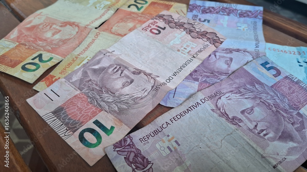 Obraz premium Brazilian real notes superimposed on a wooden background