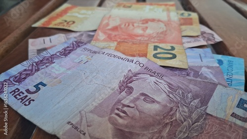 Brazilian real notes superimposed on a wooden background