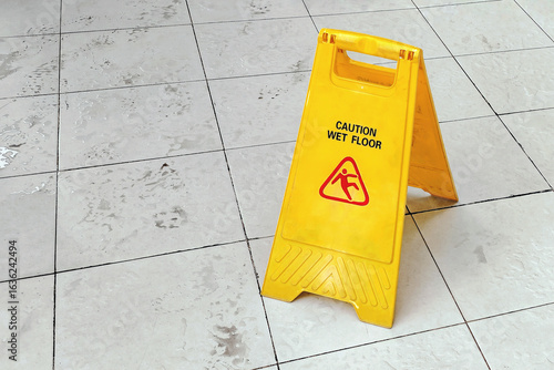 Wallpaper Mural Yellow sign with the words "Caution: Wet Floor" on a rain-stained tile floor. This safety warning is used to prevent accidents in public areas. Torontodigital.ca