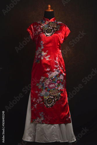 Cheongsam or qipao, Chinese traditional clothes with satin skirt on a display mannequin.	
