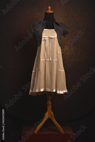 Cute mini dress in beige color with bolero jeans on a mannequin display