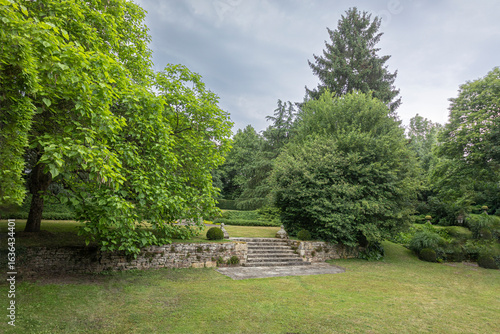 Lush garden with stone steps under cloudy sky