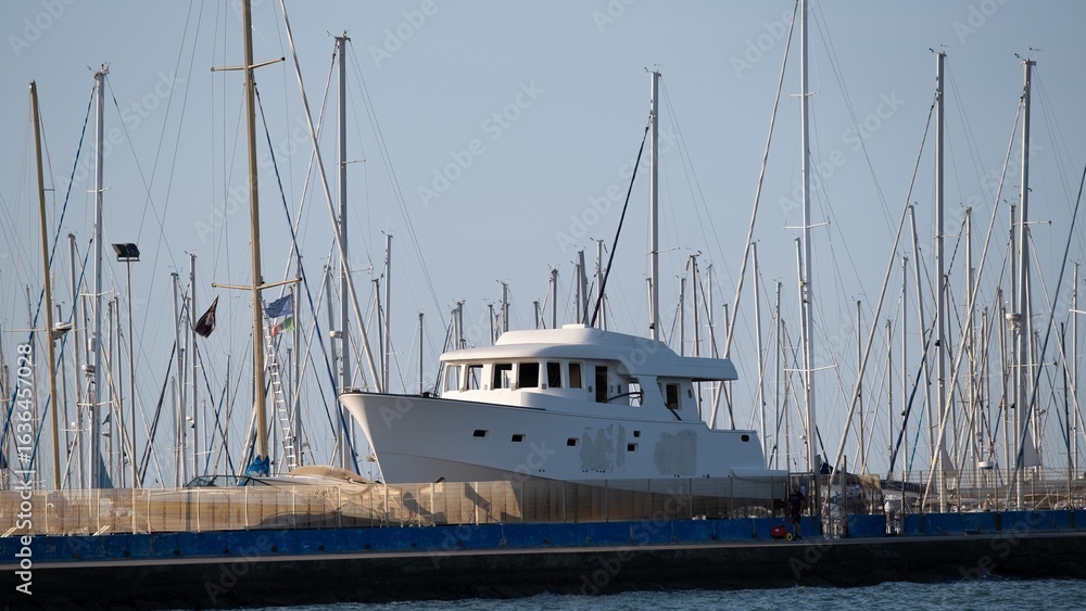 Fototapeta premium Luxury yacht in marina with sailboat masts