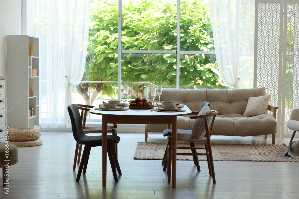 Fototapeta premium Beautiful table setting, chairs and decor in dining room. Interior design