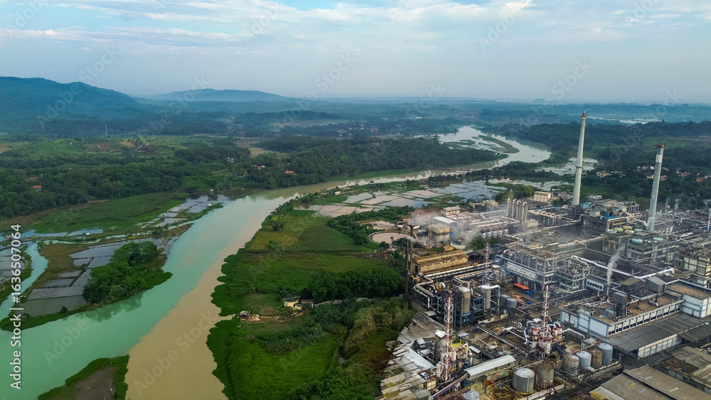 Fototapeta premium Aerial drone view of a large industrial factory complex with warehouses, chimneys, and storage tanks in Asia