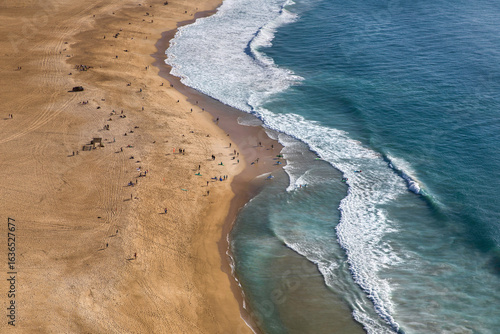 The surfers on Praia da Nazare, Portugal