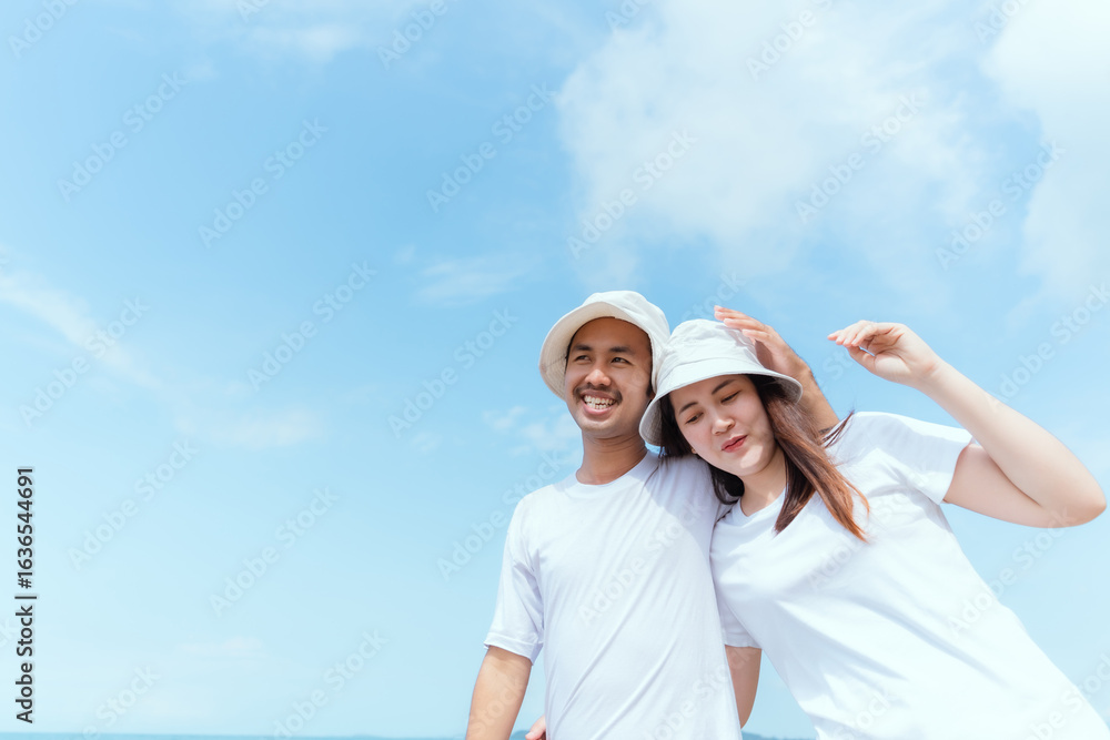 Young couple enjoys a sunny day walking hand in hand on a sandy beach near the ocean Young couple enjoys a sunny day walking hand in hand on a sandy beach near the ocean