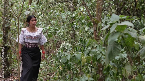 Indigenous woman walking through lush forest