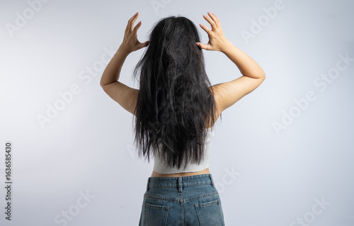 Photos Woman displays damaged tangled hair back view hair care concept against a light