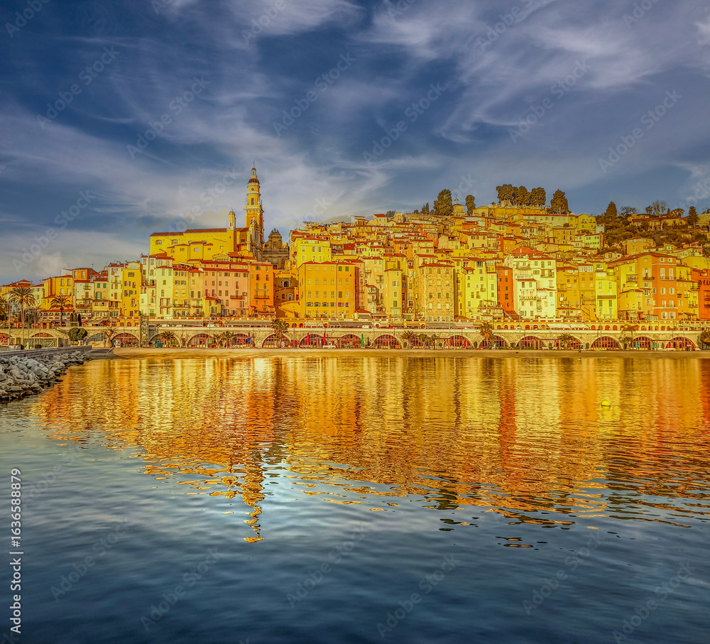 Naklejka premium Les chaudes couleurs de la ville de Menton à la frontière italienne dans le Sud de la France et son reflet dans la méditerranée