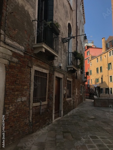 Venetian houses with laundry hanging above a canal.
