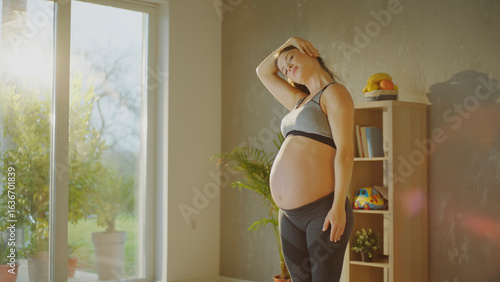 фотографія Pregnant woman doing gentle exercises at home in the living room