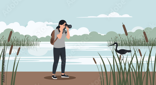 Female Photographer Capturing a Black Heron by Lake Under Blue Sky