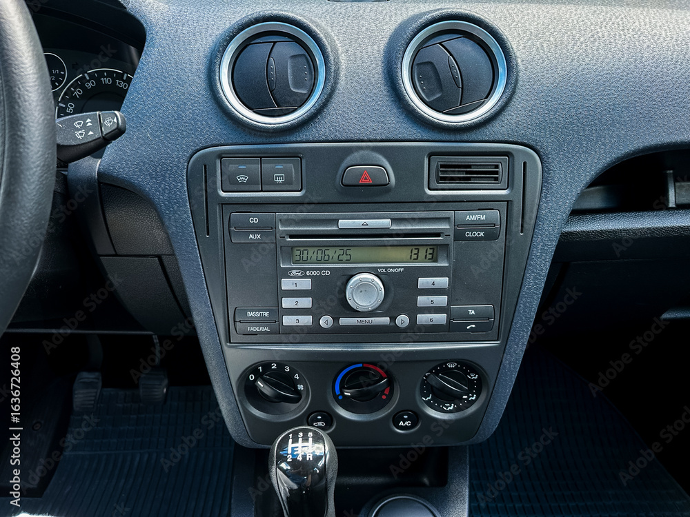 Fototapeta premium The modern car dashboard is equipped with an advanced audio system alongside intuitive climate controls, providing drivers with a seamless and comfortable user experience while on the road